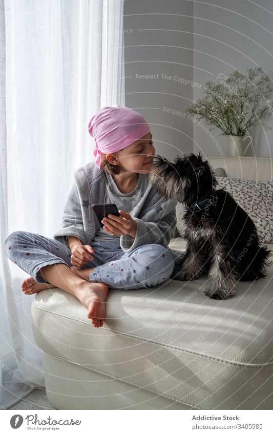 Süßes kleines Kind spielt mit Hund im Bett und hält Smartphone spielen krank Junge Streicheln Haustier heimwärts züchten Therapie Tier männlich Glaube Liebe
