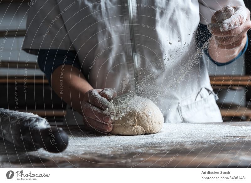 Getreidebäcker, der den Teig auf dem Tisch knetet Bäcker kneten Teigwaren Mehl Bäckerei Koch Küche Bestandteil Lebensmittel vorbereiten Brot Arbeit Job