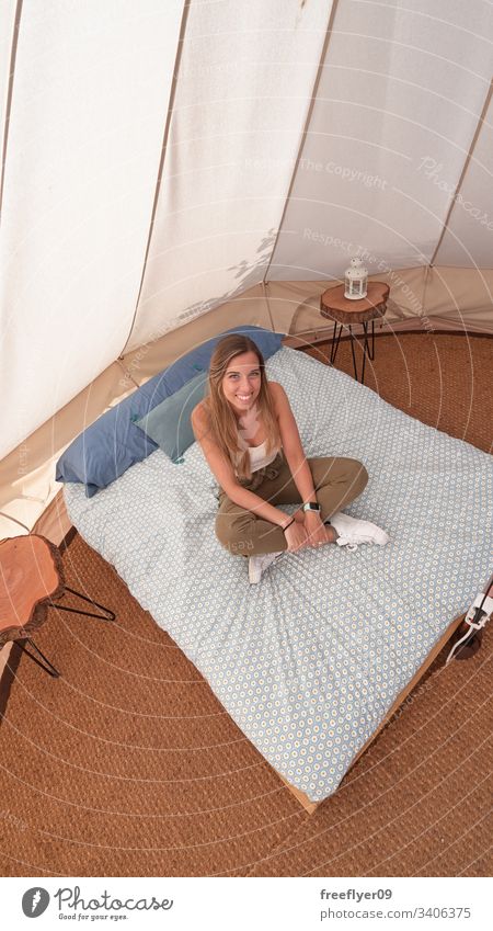 Junge Frau auf der Innenseite eines Campingzeltes Tourismus wandern Zelt glamourös groß Standort Urlaub im Freien Komfort Laken schön bequem Sommer im Inneren