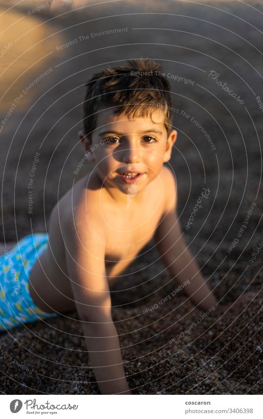 Porträt eines kleinen Jungen, der auf dem Sand liegt Strand Strandurlaub schön sorgenfrei Kaukasier Kind Kindheit Küste Textfreiraum niedlich nach unten Gesicht