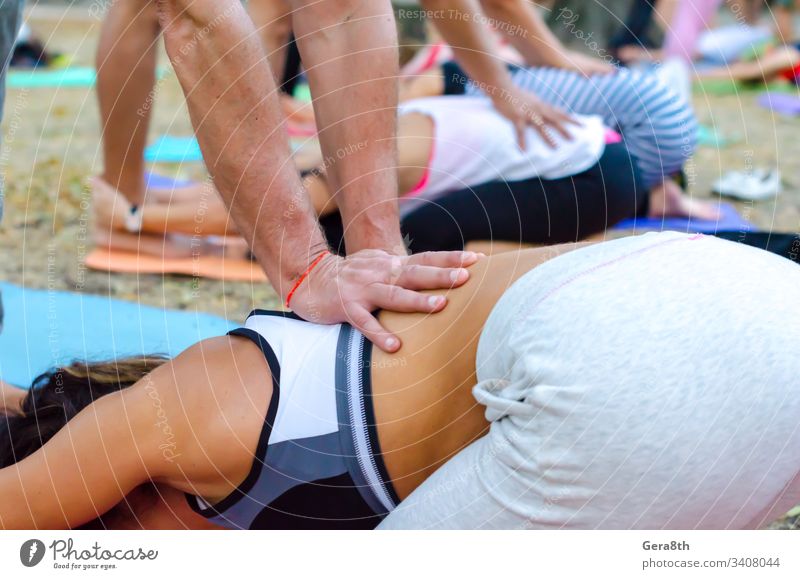Mann und Frau führen Asana-Paar-Yoga aus Amulett Rücken schlagend blau nach der Zeit Windstille Leichtigkeit Übung Fuß Boden Menschengruppe Gruppen-Yoga Hände
