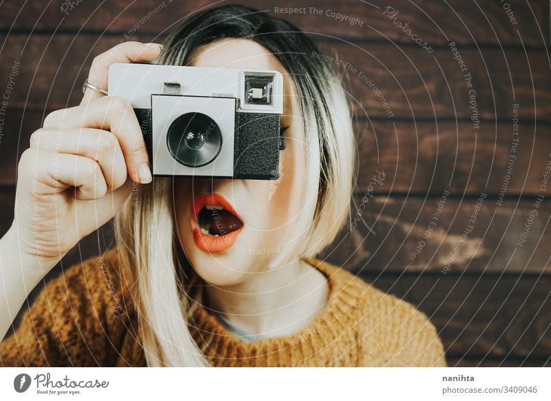 Junge Frau, die mit einer analogen Kamera fotografiert Fotokamera altehrwürdig Fotografie cool trendy retro jung Jugend artits Kunst frisch Frische Ombre Stil