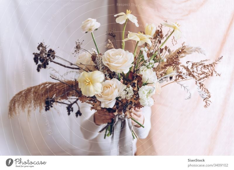 Junge Frau in einem weißen Kleid mit einem Blumenstrauß in der Hand. Vintage, romantisches Konzept. Mädchen weiches Licht schön altehrwürdig Hochzeit jung