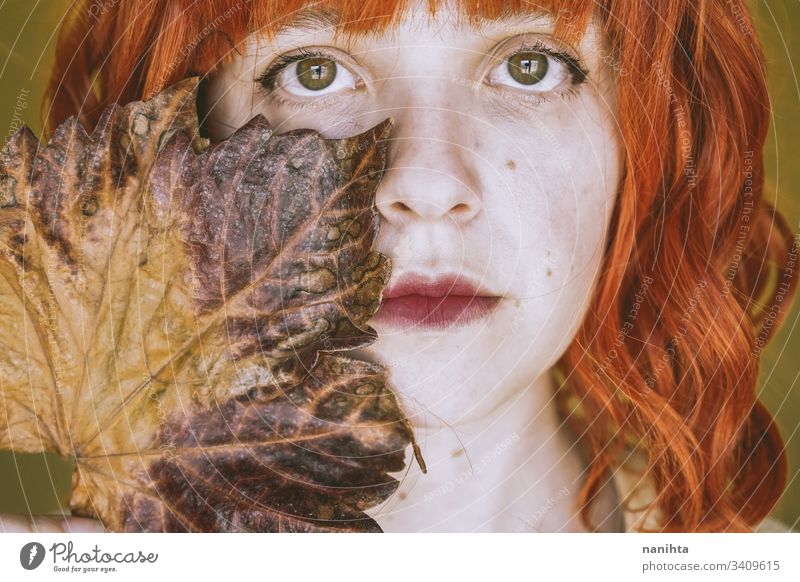 Rothaarige junge Frau, die von einem trockenen Herbstblatt bedeckt ist fallen lassen Blatt Porträt Kunst künstlerisch Rotschopf rote Haare filigran trocknen