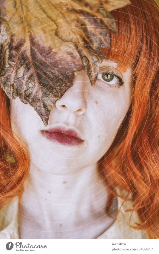 Rothaarige junge Frau, die von einem trockenen Herbstblatt bedeckt ist fallen lassen Blatt Porträt Kunst künstlerisch Rotschopf rote Haare filigran trocknen