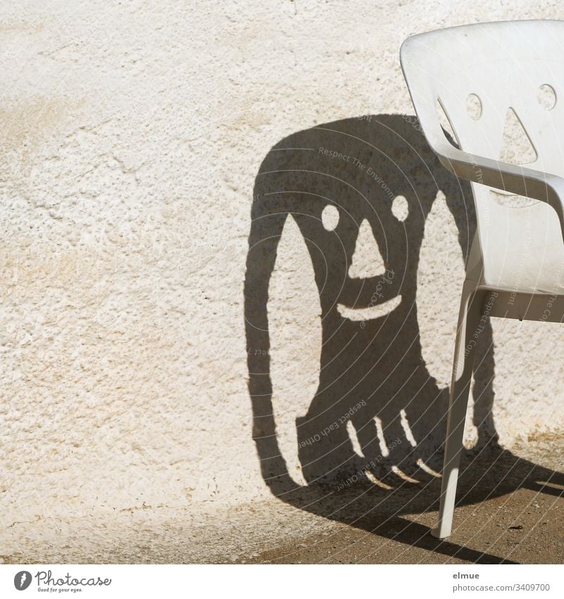 lustiger Schatten eines Plastikstuhles Stuhl Campingstuhl lachen Gesicht Mauer Fröhlichkeit smile Möbel Menschenleer Außenaufnahme Häusliches Leben Gartenstuhl