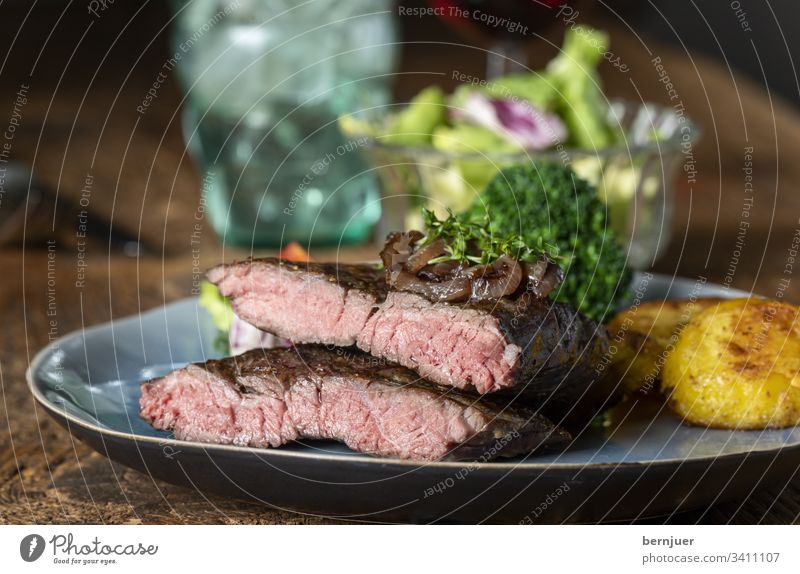 Hälften eines Steaks auf dem Teller Rindersteak Filet argentinisch Hauptgang karamellisiert Zwiebel Nahaufnahme Rinderhüfte saftig lecker Fleisch Essen
