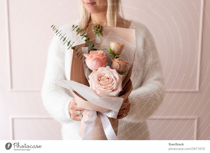 Frau hält einen Rosenstrauß Blumen Blumenstrauß Hand Beteiligung schön Halt Hintergrund geblümt weiß Geschenk Geben frisch Frühling rosa Roséwein Tag Schönheit
