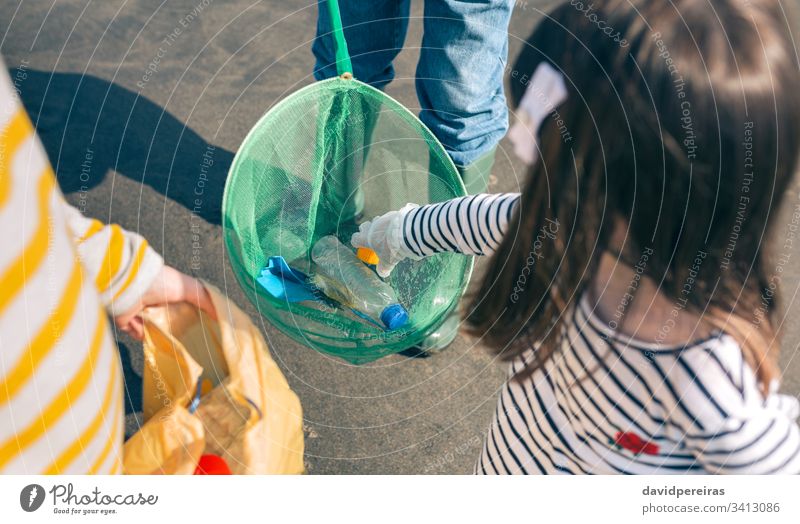 Freiwillige, die den Müll aus dem Meer holen Draufsicht Fischernetz Kunststoff MEER Ufer Großvater Enkel zeigend Umwelt Müllsäcke unkenntlich Flasche