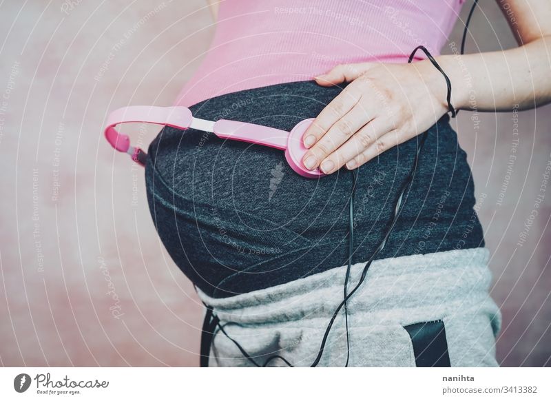 Junge Mutter legte ihrem Baby während der Schwangerschaft Musik in den Bauch schwanger Mama Kopfhörer Headset Entwicklung Wachstum Leben Gesundheit leiure