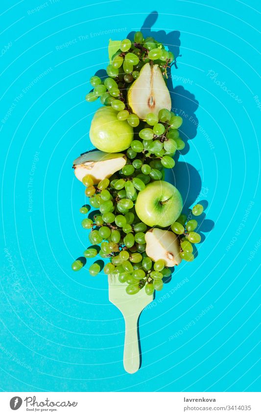 Komposition mit reifen Trauben, Birnen, Äpfeln und grünem Pinsel auf blauem Hintergrund Diät Vegetarier frisch Bestandteil Frühling organisch Lebensmittel