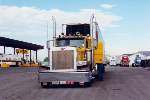 Peterbilt Truck Lastwagen Fernfahrer Fahrer gelb Tankstelle Verkehr Gefolgsleute Kühlwagen Gasstation USA Zugmaschine (LKW)