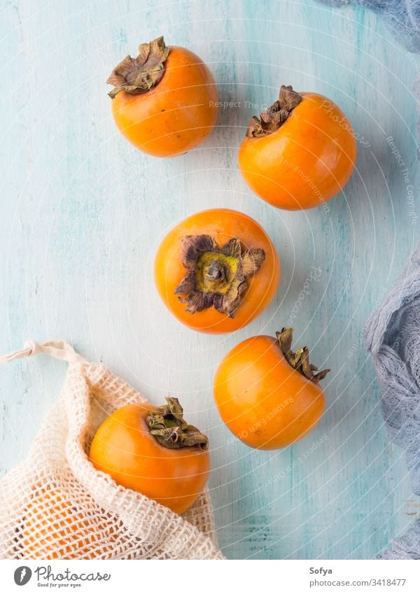 Reife Kakis auf türkisfarbenem Hintergrund Persimone roh Lebensmittel frisch Frucht Winter Herbst saisonbedingt Gesundheit Bestandteil reif Ernährung orange