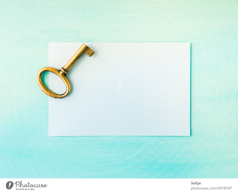 Alter Messingschlüssel und leere Papierkarte altehrwürdig Taste Postkarte Hinweis schreiben blanko Symbol Tür offen grün Pastell Farbe Hintergrund Licht oben
