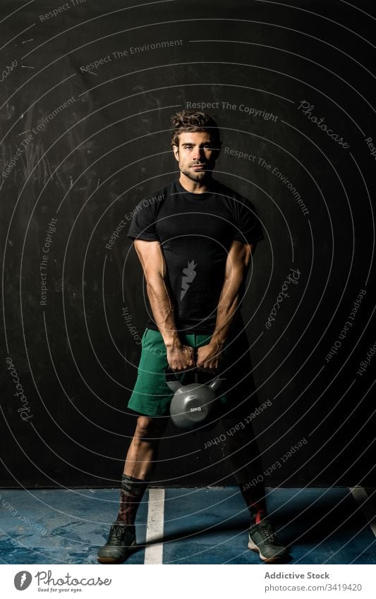 Muskelsportler mit Kettlebell im Fitnessstudio Sportler Gewichtheben operativ Training muskulös Gesundheit männlich Athlet Übung Kraft stark Körper passen