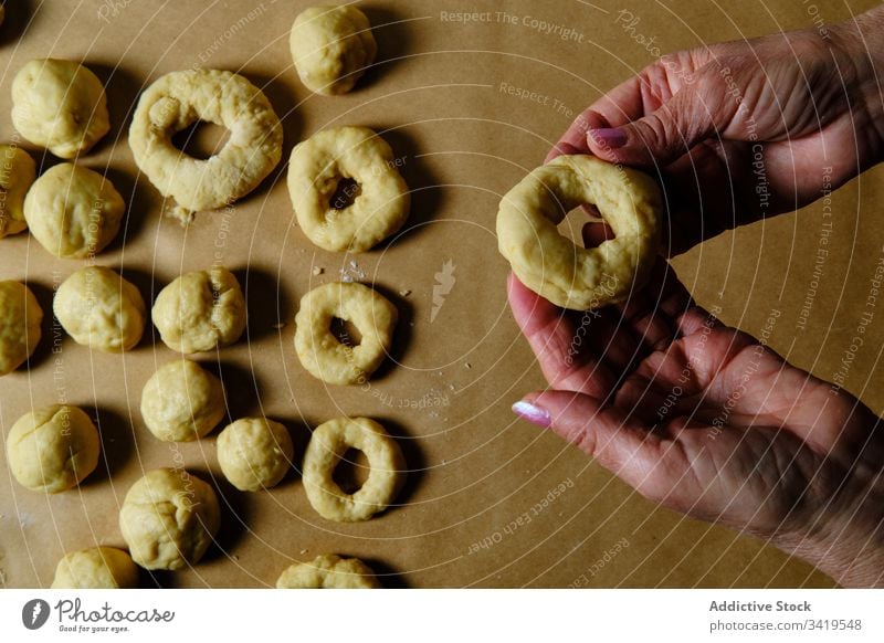 Nutzpflanzenweibchen machen Donuts aus Teig Frau Krapfen Koch Teigwaren Tisch Ring Form heimwärts Gebäck Lebensmittel frisch Snack Bäckerei Dessert süß Mahlzeit