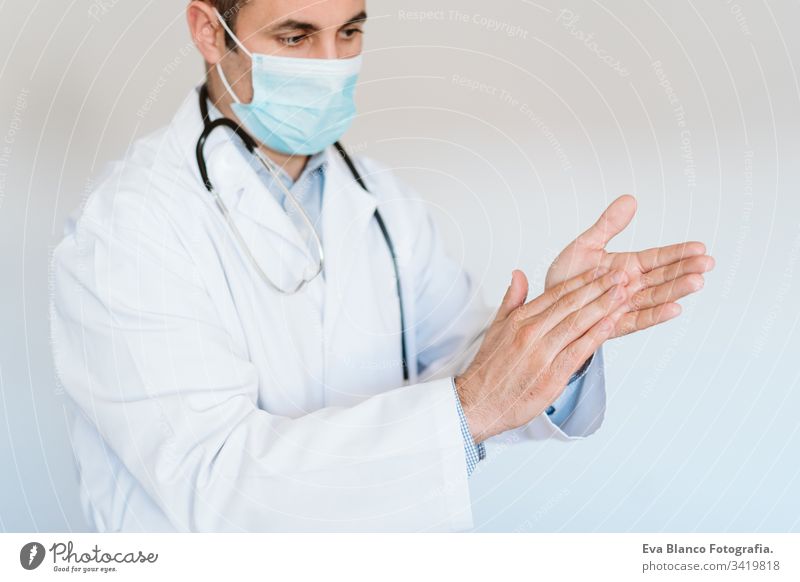 kaukasischer Arzt mit Schutzmaske und Handschuhen im Haus. Verwendung eines Alkoholgels oder eines antibakteriellen Desinfektionsmittels. Hygiene- und Coronavirus-Konzept