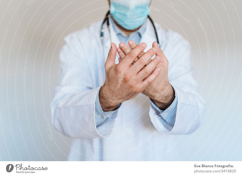 kaukasischer Arzt mit Schutzmaske und Handschuhen im Haus. Verwendung eines Alkoholgels oder eines antibakteriellen Desinfektionsmittels. Hygiene- und Coronavirus-Konzept