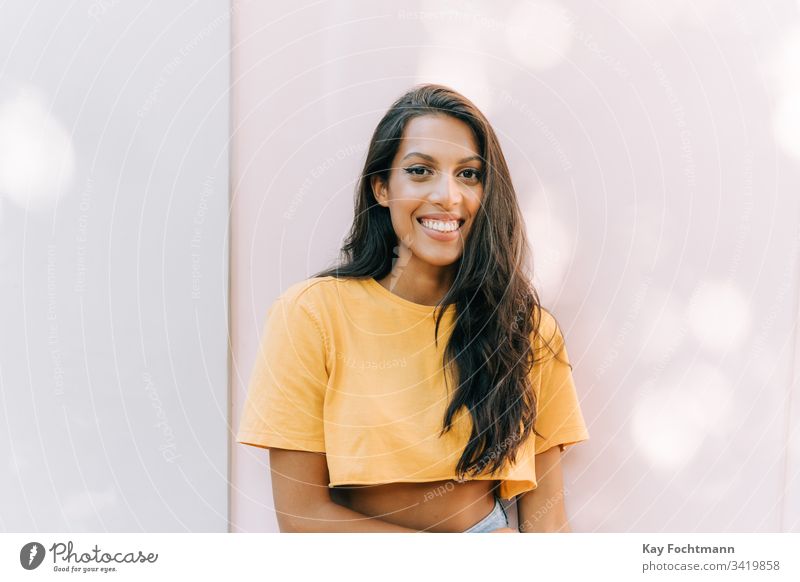 lateinamerikanische Frau lächelt vor weißem Hintergrund 20s Erwachsener attraktiv schön Schönheit Brasilien brünett sorgenfrei lässig heiter Selbstvertrauen