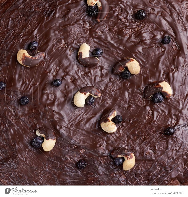 Textur eines gebackenen Brownie-Schokoladenkuchens mit gegossener Schokolade. Gekochte hausgemachte Speisen Cashewnuss braun Kakao Kuchen Hintergrund Bäckerei