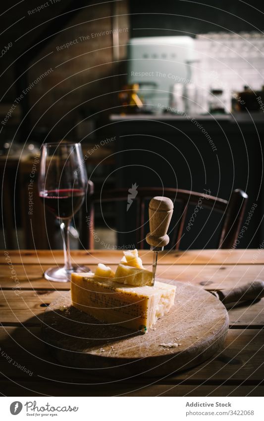 Käse und ein Glas Wein auf dem Tisch Rotwein hölzern rustikal Restaurant trinken Alkohol dienen Messer lecker geschmackvoll Spielfigur Holzplatte Dienst Bar