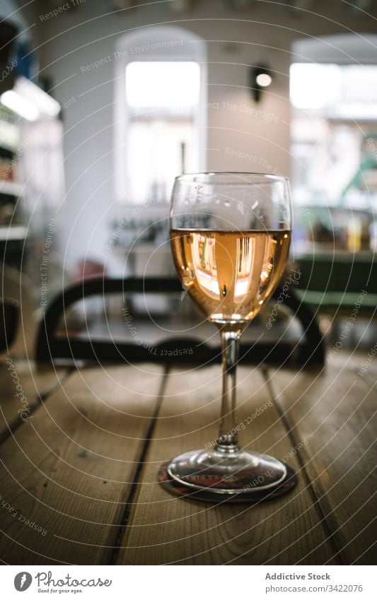 Glas Wein auf Holztisch Tisch hölzern rustikal Weinglas trinken Alkohol Bar Restaurant Getränk liquide Pub durchsichtig Tradition Glaswaren golden