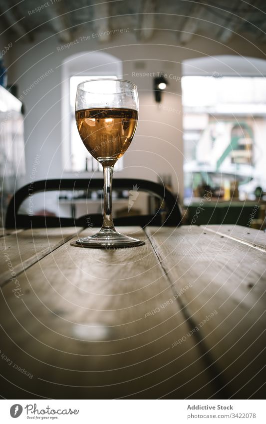 Glas Wein auf Holztisch Tisch hölzern rustikal Weinglas trinken Alkohol Bar Restaurant Getränk liquide Pub durchsichtig Tradition Glaswaren golden