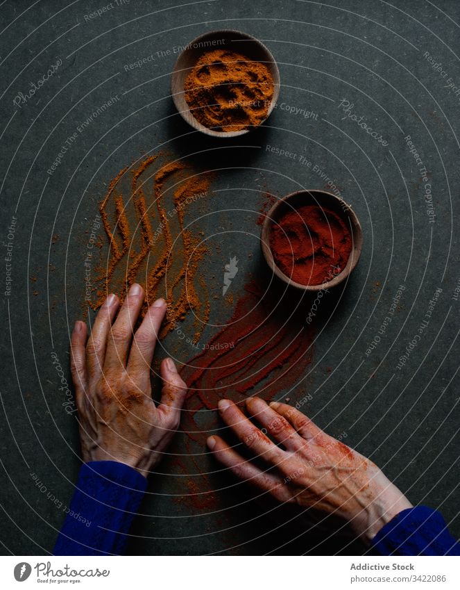 Verschüttete Gewürzpulver auf Männerhände Pulver rot Paprika Zimt Hand verschütten natürlich aromatisch kulinarisch Lebensmittel Peperoni Boden