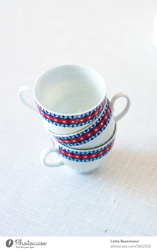 Tassen Stapel Service Kaffeeklatsch retro rot blau weiß Teetasse Kaffeetasse drei Tisch Gedeck Detailaufnahme Nahaufnahme Schwache Tiefenschärfe Muster Geschirr