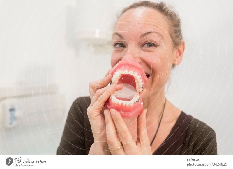 Lustige Frau spielt mit den Kiefern in der Zahnarztpraxis Spaß offen Medizin Mund horizontal Zahnmedizin Gesicht Zahnbürste Mädchen Menschen cary Humor