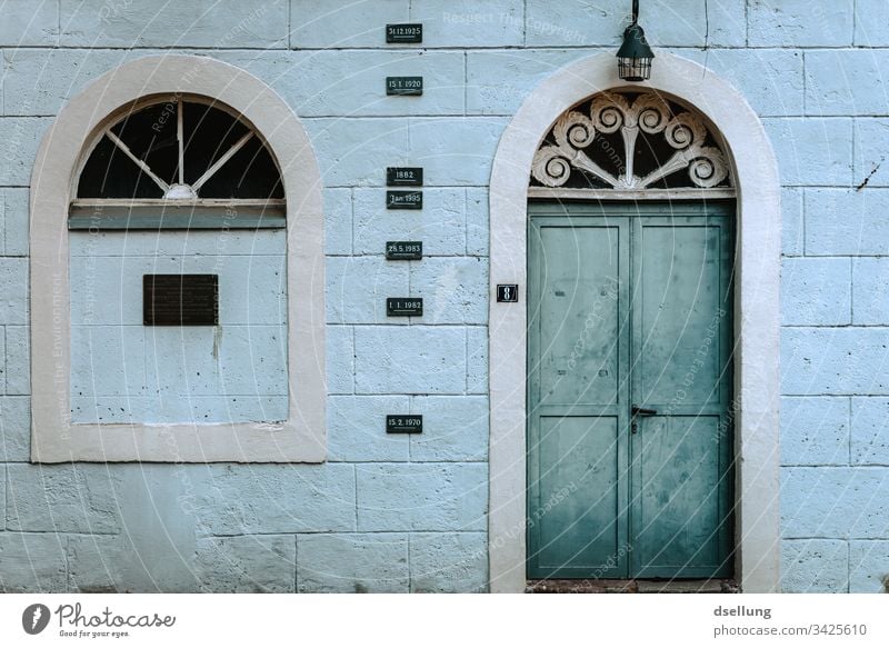 Verwitterte Fassade mit türkiser Tür Haus Fenster Ordnung Menschenleer Architektur Außenaufnahme abstrakt ästhetisch Gebäude Farbfoto Tag grau trashig Wand
