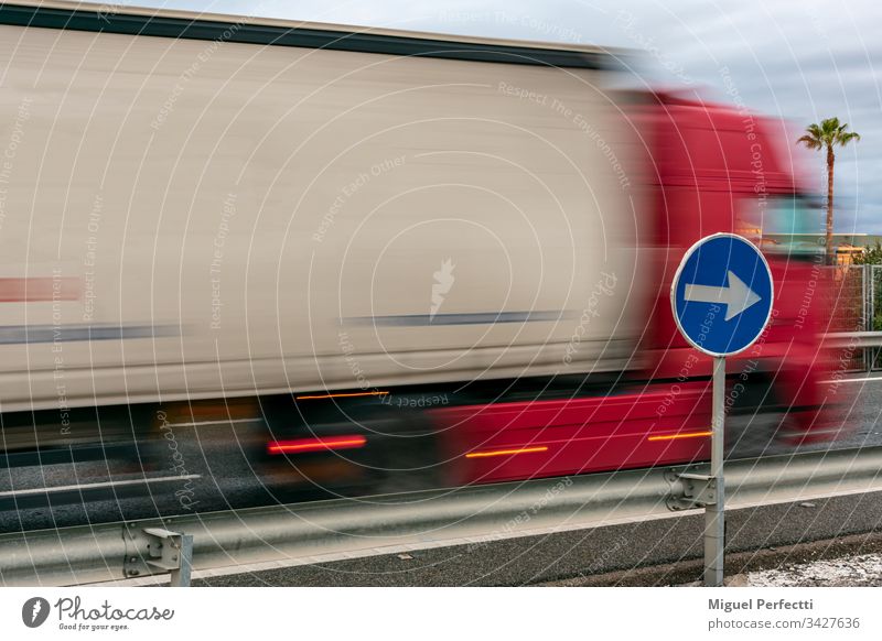 Obligatorisches Schild mit einem Umzugswagen im Hintergrund Lastwagen Güterverkehr & Logistik Straßenverkehr Farbfoto fahren Fahrzeug Geschwindigkeit bewegend