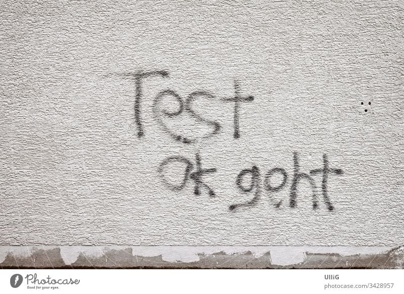 Test Ok Geht - Grafitti an einer Hauswand. Schrift Text Botschaft Message Schmiererei Vandalismus Grafitto Oberfläche Schriftzüge Zeichen Symbol beschmieren