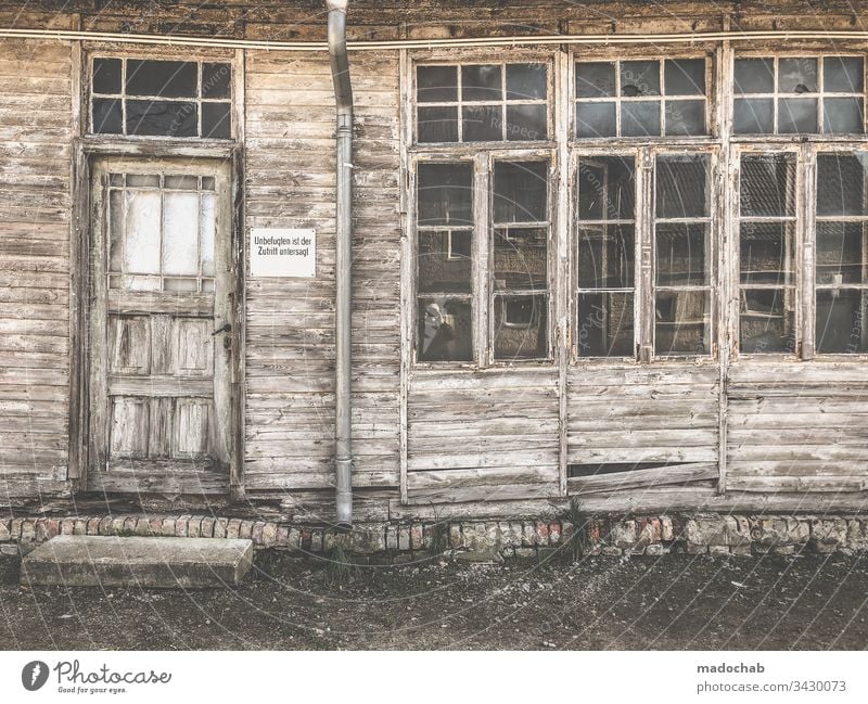Verfallene und verwitterte Hausfassade Ruine Holz Bretter kaputt zerstört Fassade Zerstörung Wand Fenster Renovieren Vergangenheit Vergänglichkeit Menschenleer