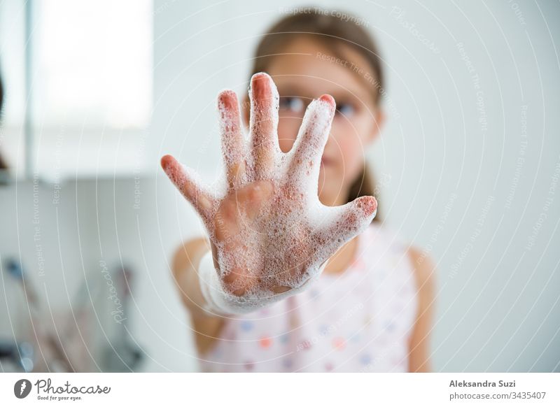 Kleines Mädchen wäscht ihre Hände mit Wasser und Seife im Badezimmer. Händehygiene und Prävention von Virusinfektionen. bezaubernd Bakterien Schaumblase Pflege