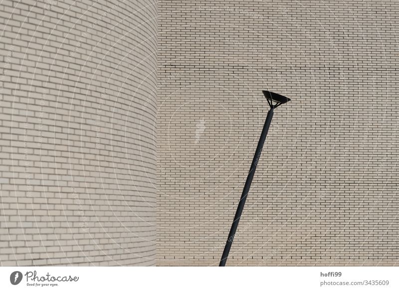 Straßenlampe mit Backsteinmauer Wand Architektur Minimalismus Neigung Zerstörung Verfall Laternenpfahl Fassade Mauer Gebäude ästhetisch Linie Bauwerk schräg