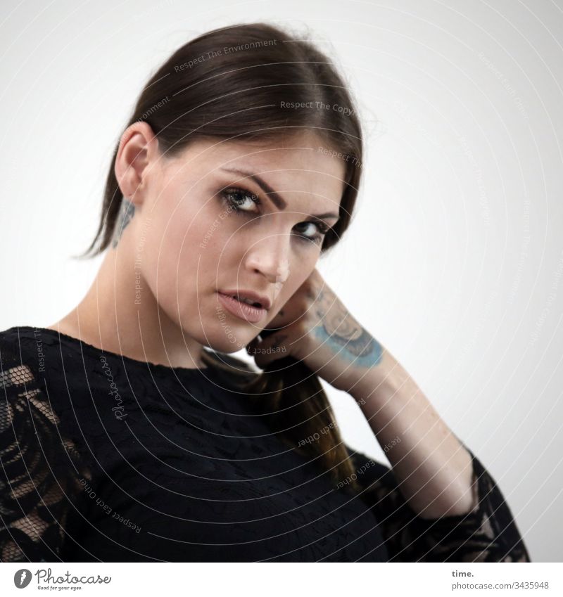 mixed emotions Frau feminin weiblich skeptisch langhaarig zopf tattoo kleid intensiv portrait blick halbprofil halten freisteller wand misstrauisch