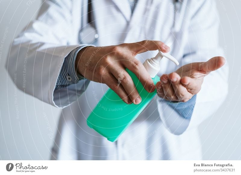 Ein Arzt, der im Haus eine Schutzmaske trägt. Er hält ein Alkoholgel oder ein antibakterielles Desinfektionsmittel in der Hand. Hygiene- und Coronavirus-Konzept. Covid-19