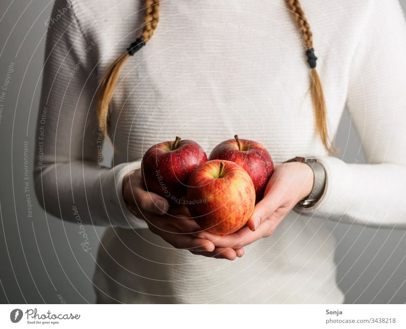 Junges Mädchen mit Zöpfen hält rote Äpfel in ihren Händen apfel verrotten Hand halten geflochten gesunde ernährung Frucht Gesunde Ernährung Foodfotografie Essen