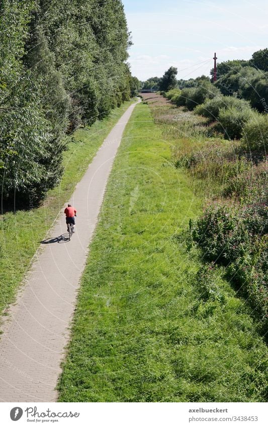 Radfahrer auf dem Radweg in der Natur Fahrradfahren Weg unkenntlich Person grün Landschaft Freizeit Erholung Sport Radfahren Aktivität im Freien Straße ländlich