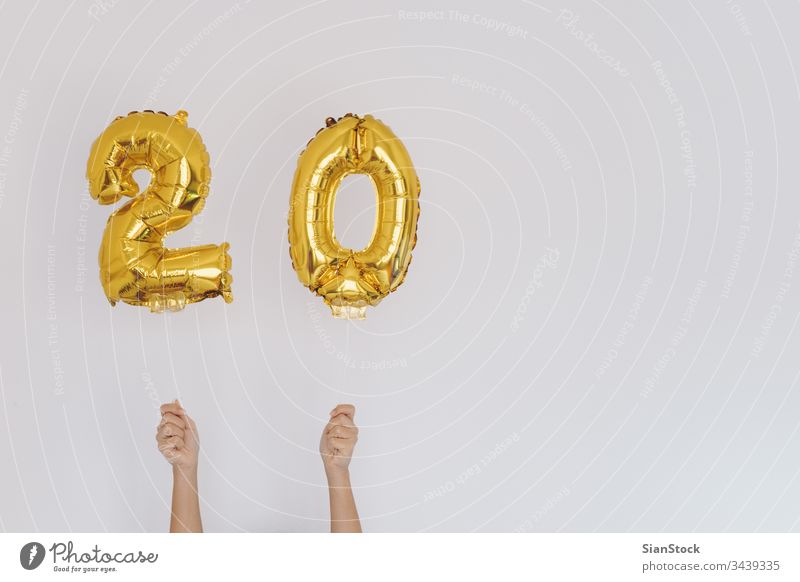 Hände halten goldene 20er-Ballons, Geburtstagskonzept Jahre neu Glück Luftballon vereinzelt Halt Beteiligung Wand Gold-Zahlen-Ballons weiß fröhlich Feiertag