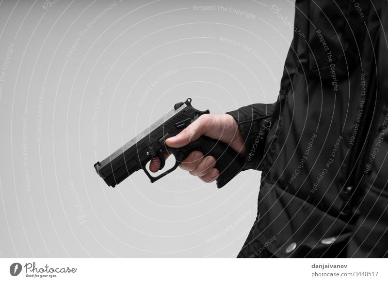 Hand mit Pistole auf weißem Hintergrund Aggression Ziel ak bewaffnet Anschlag Sturmhaube Bandit schwarz Verbrechen Krimineller gefährlich Schußwaffen Gangsterin