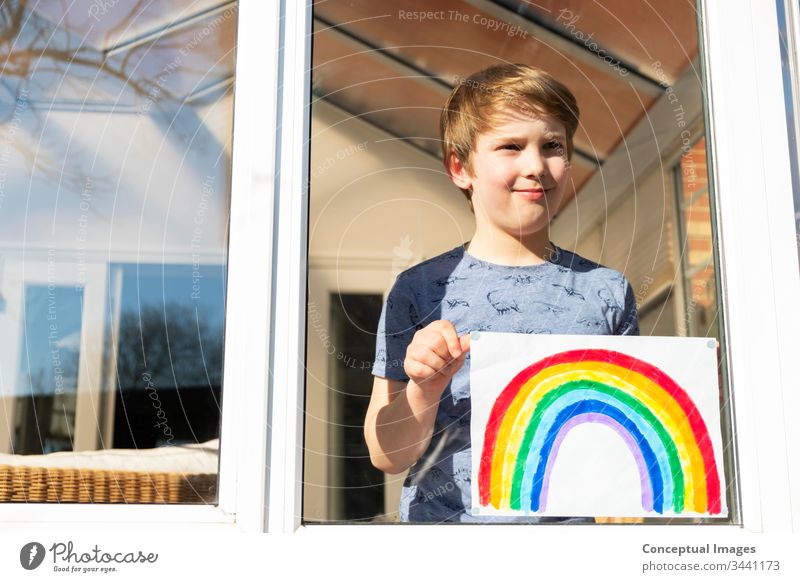 Kaukasischer Junge hält ein Bild eines Regenbogens Kindheit Zeichnung Hoffnung Tagträumen Inspiration Aspiration Kaukasier jung Künstler farbenfroh Aktivität