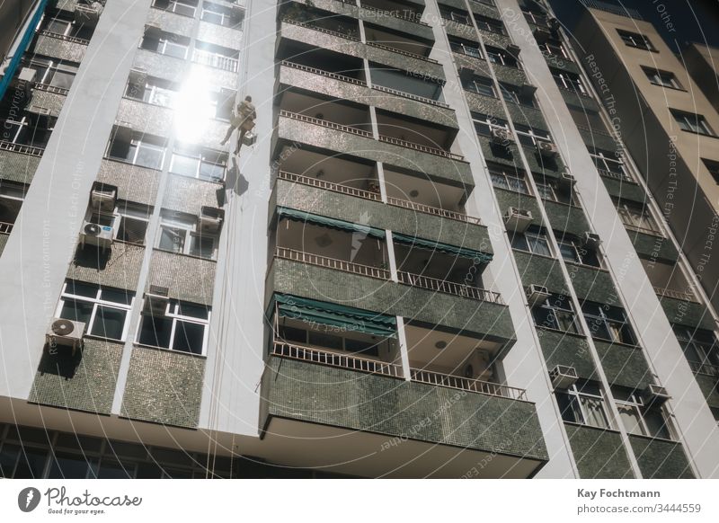 Arbeiter beim Reinigen der Fenster eines Hochhaus-Wohnblocks in Rio de Janeiro, Brasilien Gebäude Business Großstadt Sauberkeit Raumpfleger Aufstieg Klettern