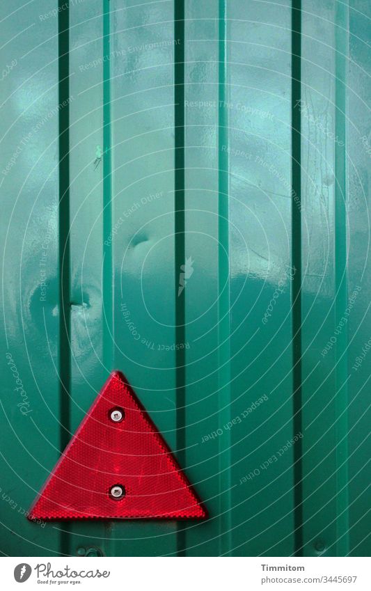 Beulen im Blech und warnender Reflektor glänzend Warnung Metall Kunststoff grün rot elegant Detailaufnahme Außenaufnahme Menschenleer Spiegelung