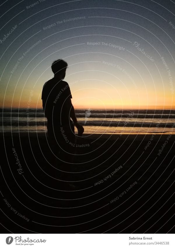 Silhoutte eines Mannes am Strand bei Sonnenuntergang Silhouette Licht Sonnenlicht Meer schön Surfer Brandung Wassersport cool Urlaubsgefühl reisen Horizont