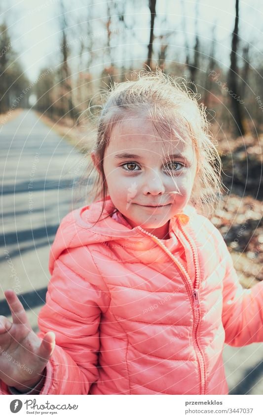 Porträt eines kleinen Mädchens, das im Park spielt und sich an einem sonnigen Herbsttag amüsiert. Echte Menschen, authentische Situationen Kind Spielen Spaß