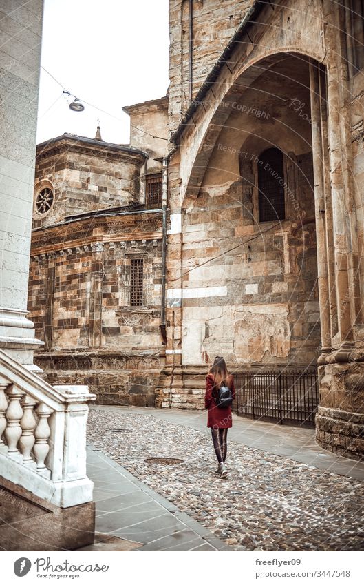 Junge Frau geht am Zentrum von Bologna vorbei Architektur Rucksack Glockenturm bologne hell Gebäude Großstadt Uhr Mantel Tag Entfernung Europa Fassade