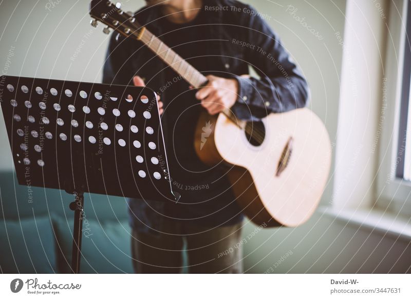 Gitarrist Gitarre Gitarrenspieler Notenständer zu Hause üben Übung übend lernen fleiß Motivation Lehrer Schüler Unterricht Notenpult Bildung Schule