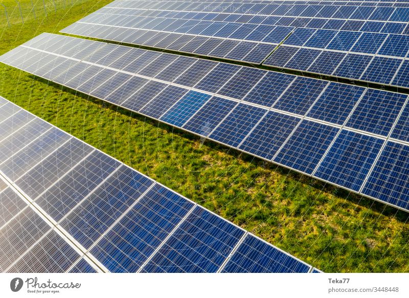 ein moderner Solarzellenpark von oben solar Sonne Sonnenstrahlen blau weiß heiß gelb Gras Wiese grün Wolken Betrachtungen Lithium moderne Solarzelle